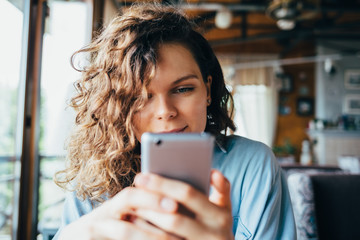 close-up portrait of young woman texting on smart phone