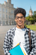 © Oleksandr - Smiling African American student in glasses with books. Happy mixed race guy near college.
