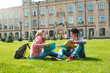 © Oleksandr - Smiling students African American male in glasses with books and a girl near college.