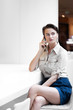 © alimyakubov - Woman speaking phone on the office.  Beautiful smiling young woman.