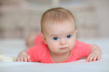 Portrait of pretty baby girl with blue eyes. Cute little baby girl looking into the camera