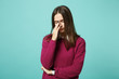 © ViDi Studio - Young sad upset perplexed disturb brunette woman girl keeping eyes closed, putting hand on nose posing isolated on blue wall background studio portrait. People lifestyle concept. Mock up copy space.