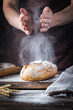 © petrrgoskov - Baker cooking bread. Man slaps flour over the dough. Man's hands Making bread