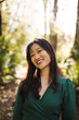 © TONL - Portrait of smiling young woman standing in forest