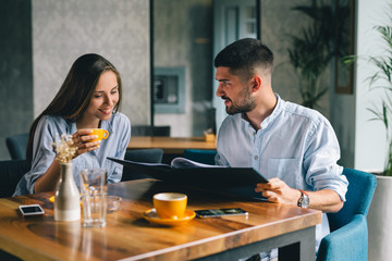 Wall Mural - A happy young couple looking at their menu's at a restaurant