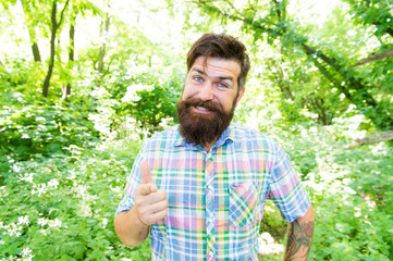 Man handsome beard and mustache in summer forest. United with environment. Summer vacation concept. Explore wild nature activity. Man bearded hipster green trees background. Emotional nature lover