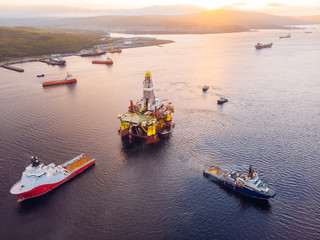 ships are transporting offshore oil rig for installation sea for repairs, aerial top view