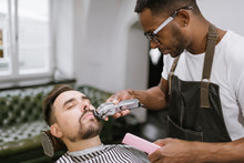 Barber Cutting Beard Of A Customer In Barber Shop