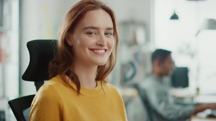 Aufkleber - Portrait of Beautiful Young Woman with Red Hair Wearing Yellow Sweater Chats with Colleague and Turns Smilingly at Camera. Successful Woman Working in Bright Diverse Office