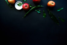 From Above Bright Red Appetizing Apples With Green Leaves And White Small Plate On Black Background