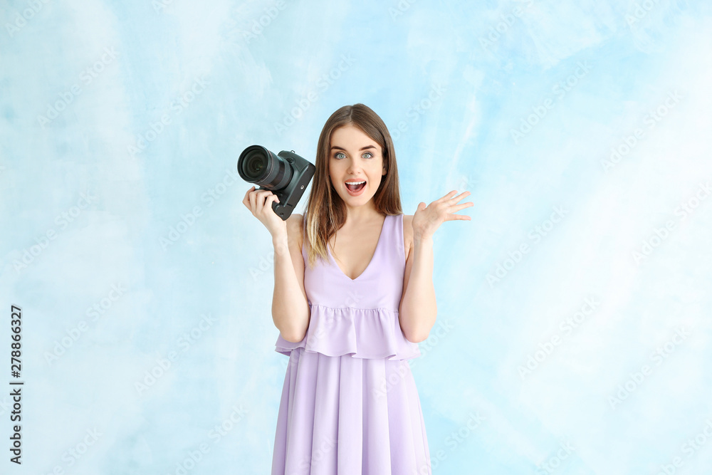 Excited female photographer on color background