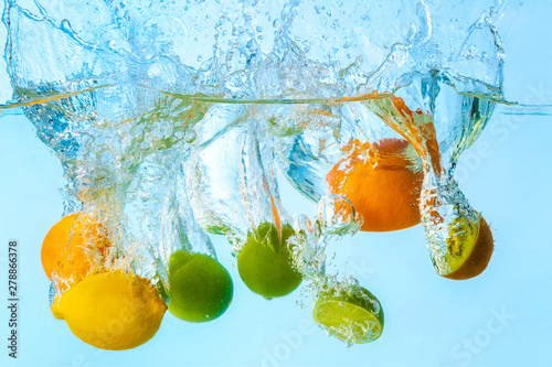  Fototapeta owoce w wodzie   spadanie-roznych-owocow-do-wody-na-jasnym-tle