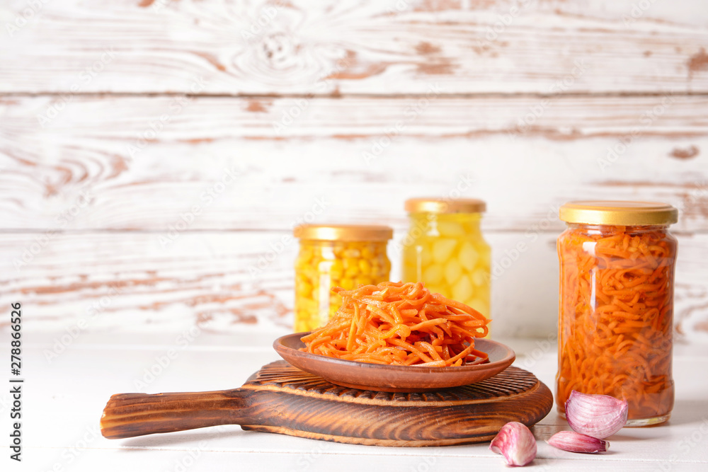 Tasty canned carrot on white wooden table
