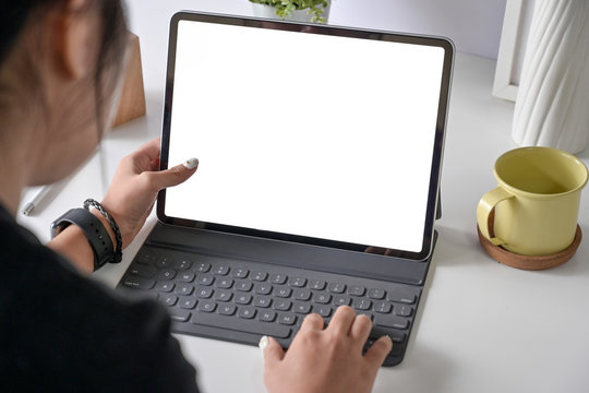 Woman freelancer is working on tablet computer with blank copy space screen for your advertising graphic display