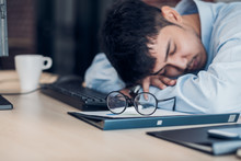 Tired Asian Businessman Sleep On Working Desk Table In Office.working Hard And Late.burn Out Syndrome.