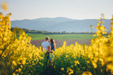 Fototapeta Kuchnia - Beautiful young couple in spring colza field
