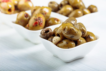 Canvas Print - Spiced green olives in oil on a  wooden table.