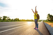 © BNMK0819 - Women tourists carrying a backpack that holds his hands up to the sky on the highway with the golden light of the sun, Happy mood from tourism.