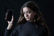 © SB Arts Media - Portrait of sad young girl on mobile suffering harassment online