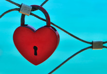 Heart-shaped Red Love Lock On A Bridge