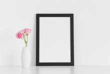 Black Frame Mockup With Pink Roses In A Vase On A White Table.Portrait Orientation.