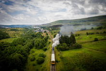 Aerial View Of Landscape With Steam Train Of The Heritage Railway In Blaenavon Driving Along Garn Lakes Local Reservce In Wales, UK