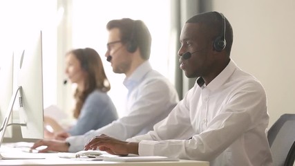 Wall Mural - focused african call center agent wear wireless headset consulting customer