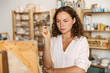 © Drobot Dean - Portrait of thoughtful concentrated artistic woman holding piece of chalk while drawing picture on canvas in workshop or master class