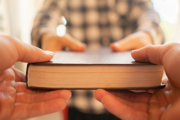 two people exchange the book, giving the knowledge to younger generation