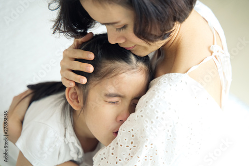 Asian Young Little Girl Is Crying On Her Mother Shoulder And Her