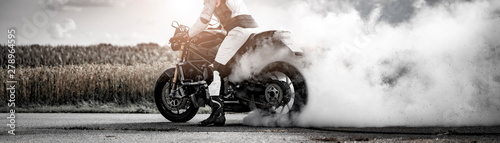 Fotomural wilder Motorradfahrer lässt die Reifen bei einem Burnout durchdrehen und macht e