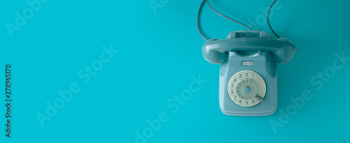 Fotomural A blue vintage dial telephone with blue background.