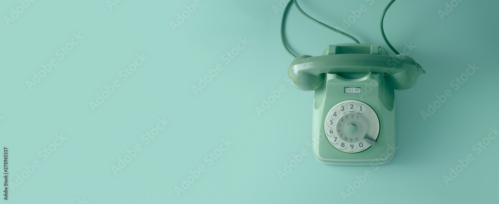 Obraz na płótnie A green vintage dial telephone with green background.	 w salonie