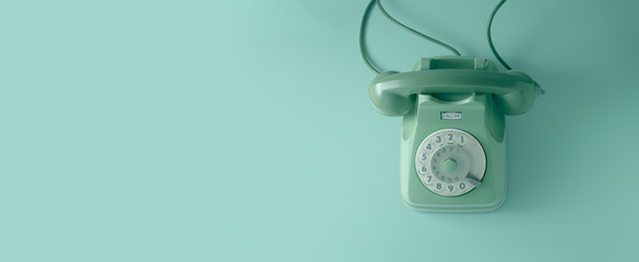 a green vintage dial telephone with green background.