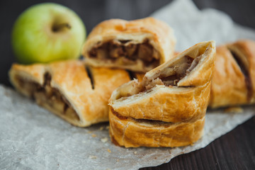 Wall Mural - strudel with apple and cinnamon on a light towel, light background