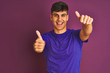 © Krakenimages.com - Young indian man wearing t-shirt standing over isolated purple background approving doing positive gesture with hand, thumbs up smiling and happy for success. Winner gesture.