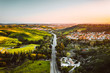 © Ryan Longnecker - Aerial view of highway through green hills and town