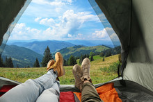 Closeup Of People In Camping Tent With Sleeping Bags On Mountain Hill, View From Inside