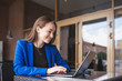 © jalisko - Business woman working behind a laptop and smiling.