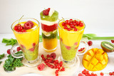 Fototapeta Kuchnia - Kolorowe warstwowe smoothie z mango, kiwi, selera naciowego, malin, porzeczek, banana, jarmużu i kremu waniliowego