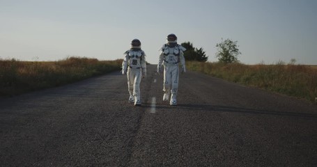 Wall Mural - Two astronauts walking on road