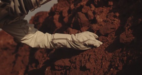 Wall Mural - Astronaut examining rock on Mars