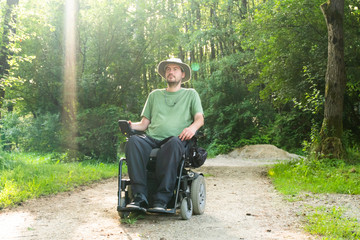 Wall Mural - Portrait photo of a handicapped man in a electric wheelchair in nature