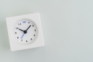 Flat lay of white rectangular alarm clock on texture white background with copy space using as time, deadline or schedule presentation wallpaper