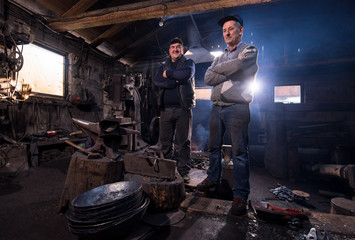 portrait of two generations confident blacksmith