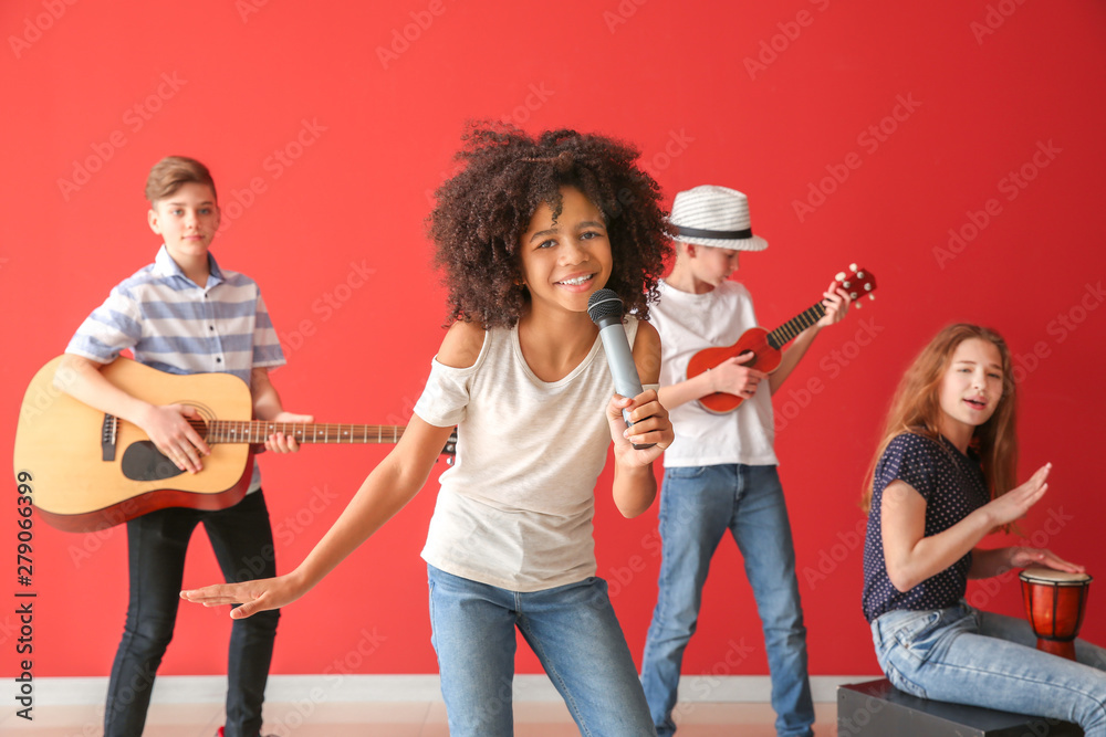 Teenage musicians playing against color wall