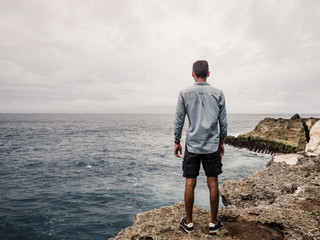 Wall Mural - a lonely man looking at the ocean.