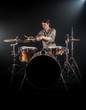 © puhimec - Professional drummer playing on drum set on stage on the black background