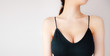Woman is Breast in Black Underwear Posing on Grey Background,Show the Bra. Cropped Close Up of Sexy Female Wearing Sport Bra (Sportswear) with Perfect Chest. Fitness and Yoga Healthy Lifestyle 