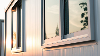 beautiful warm sunrise light shining on house glass window with town nature reflection in the mornin